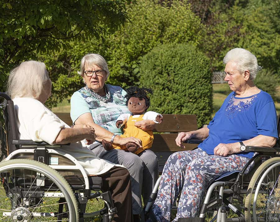 Une personne âgée créant du lien social avec les autres résidents grâce à une poupée d'empathie Personne âgée créant du lien social avec les autres résidents grâce à une poupée d'empathie