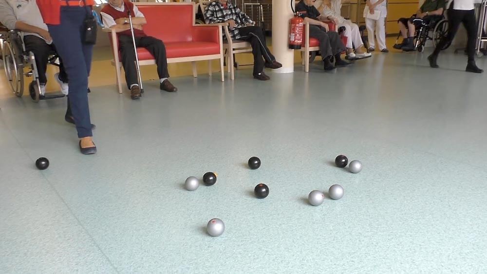 vue sur une partie de pétanque en maison de retraite avec les boules de pétanque molle d'interieur